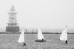 Sailing around Stamford Harbor Light in the fog. Black and white